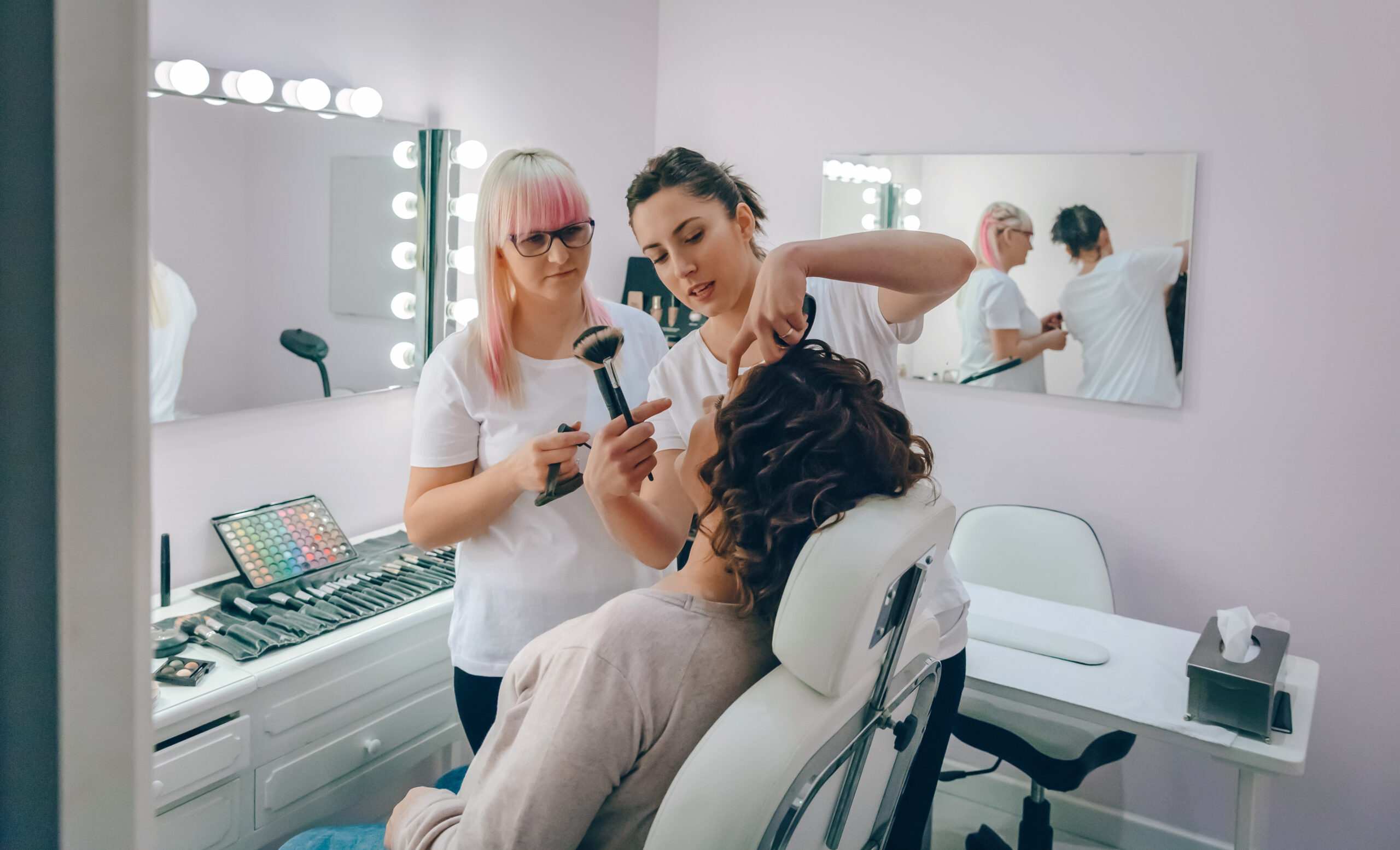 cosmetology students applying makeup