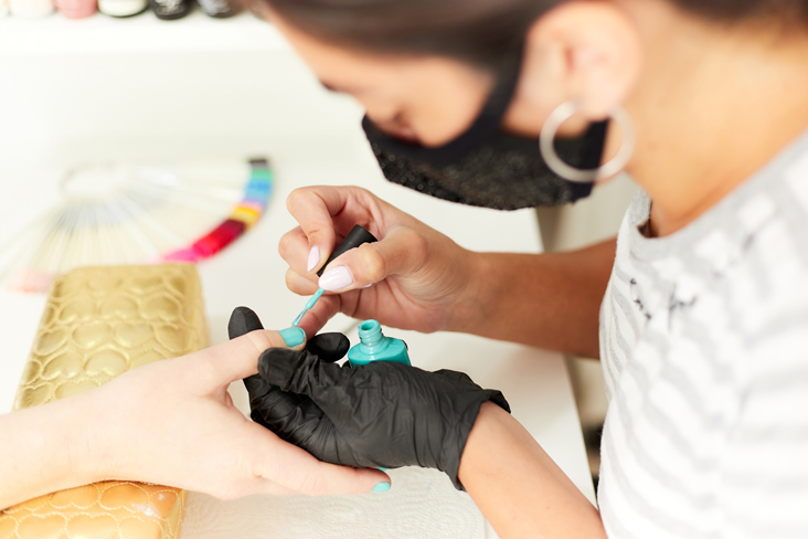 woman painting nail in salon