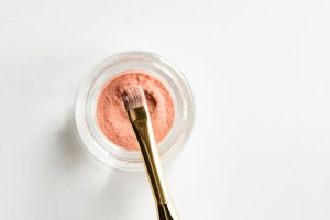pink powdered cosmetic on a dainty brush