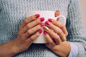 Pink nails holding mug