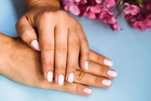 Manicured hands next to flowers