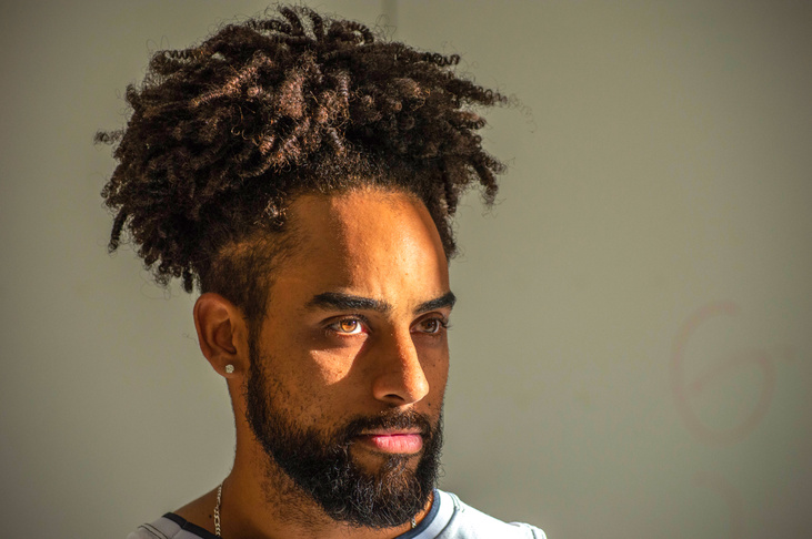 man posing with curly ponytail