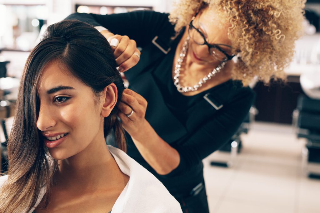 hairstylist styling a girls hair