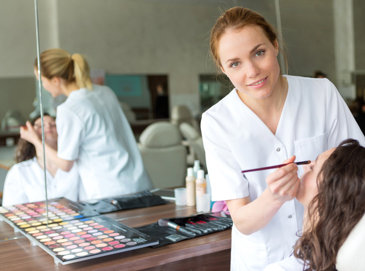 student applying shadow to client’s eyes