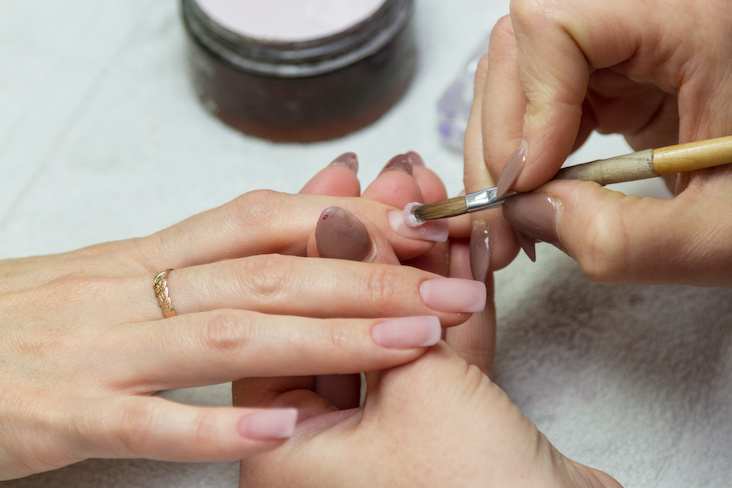 applying acrylic nails with brush