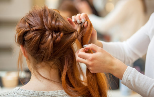 hairstylist doing french braids for client