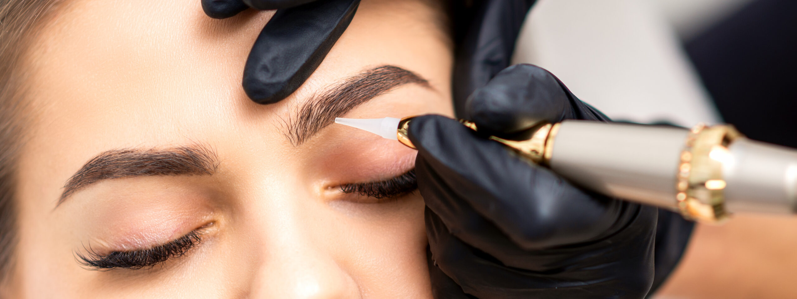 artist tattooing eyebrows