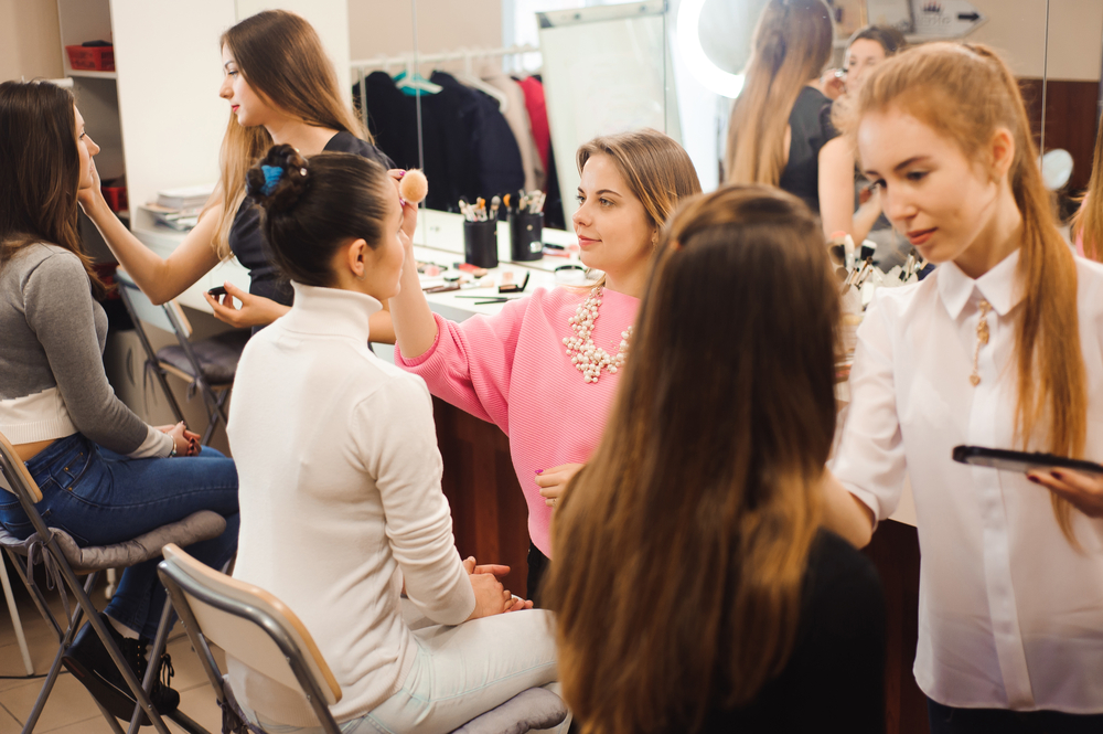 3 beauty school students practicing makeup