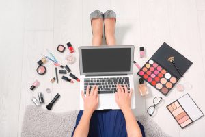 beauty blogger working laptop surrounded my makeup