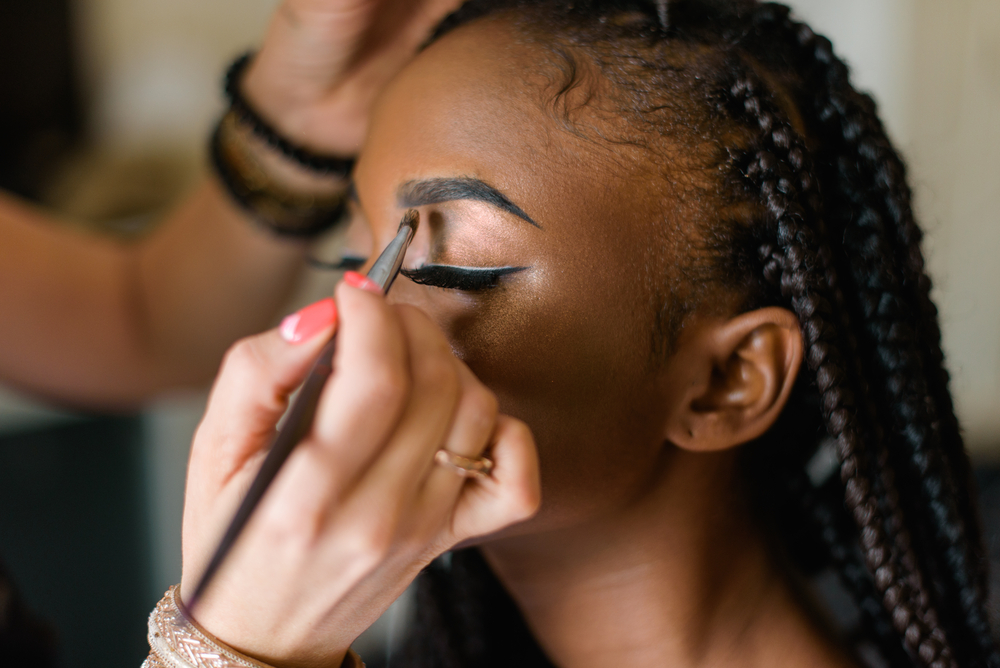 black model getting her makeup done