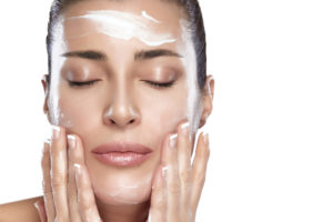 woman applying facial moisturizer