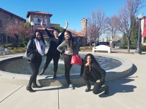 Evergreen employee "Lela" posing with friends outside near a fountain