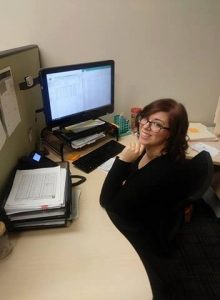 Evergreen employee "Sarah" sitting at desk smiling at camera