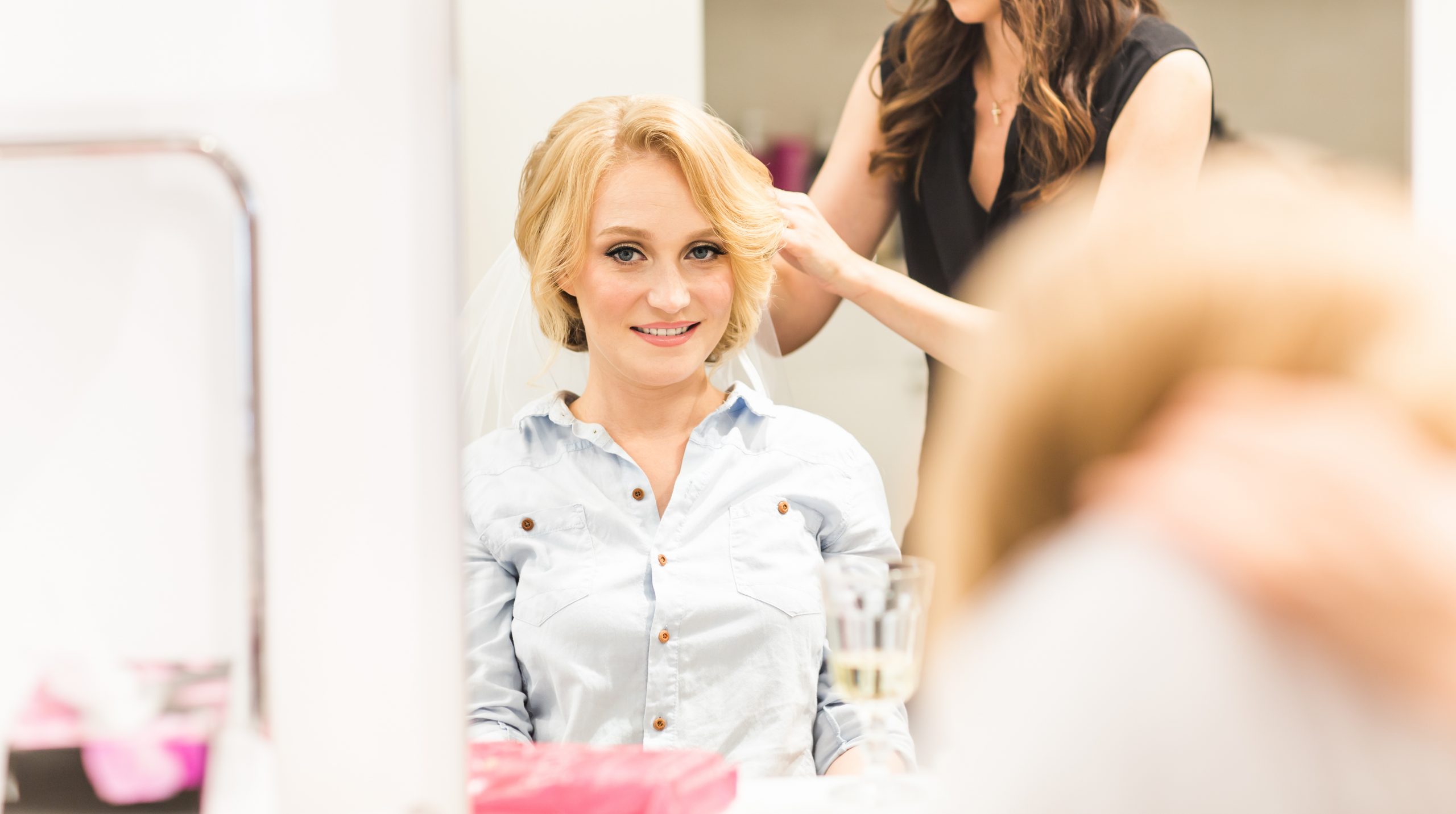 Bridal Hairstylist putting veil on bride