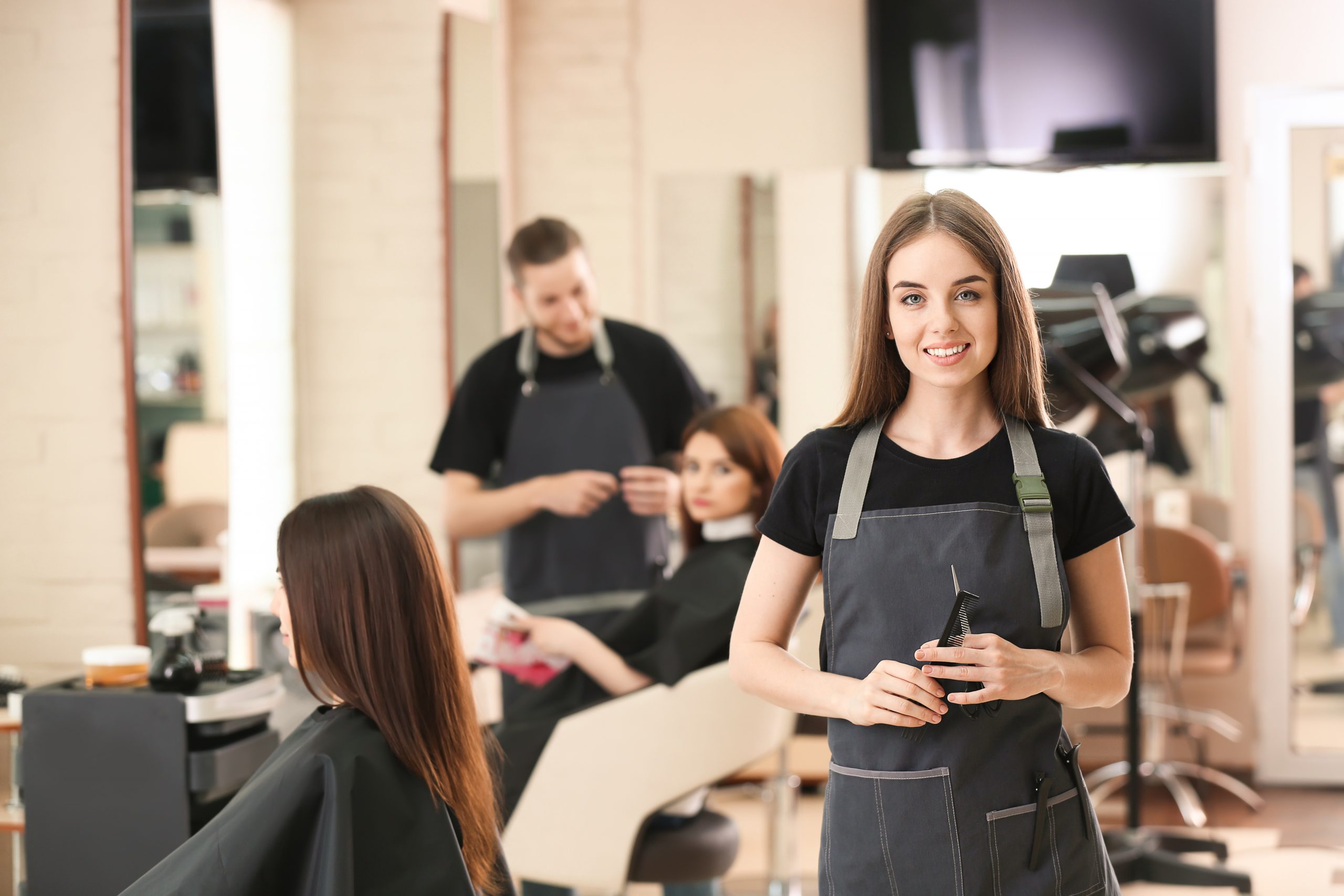 Young hairstylist in a salon holding a comb