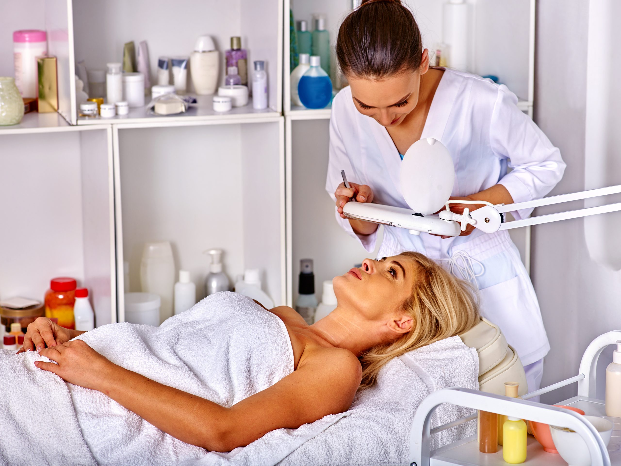 Esthetician examining face