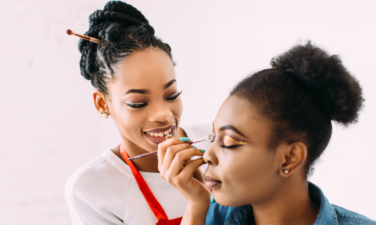 applying eyeshadow on student