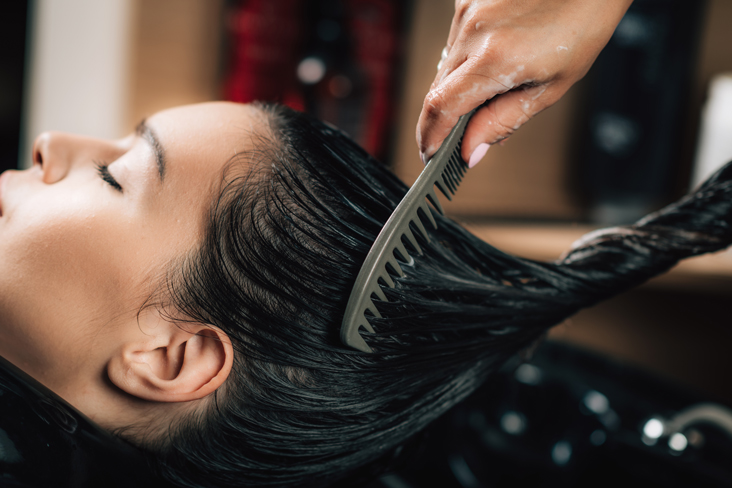 combing hair over salon sink