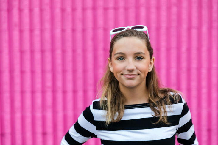 woman standing before pink wall